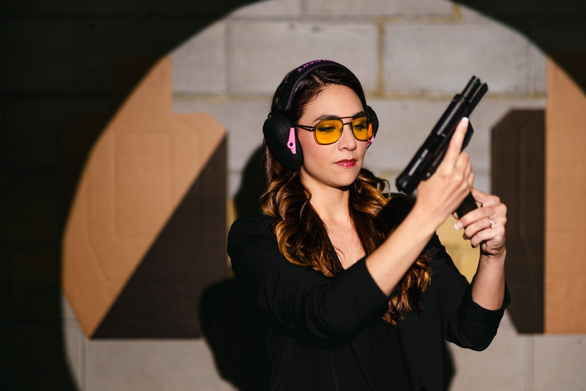 A woman with eye protection ready on the firing line