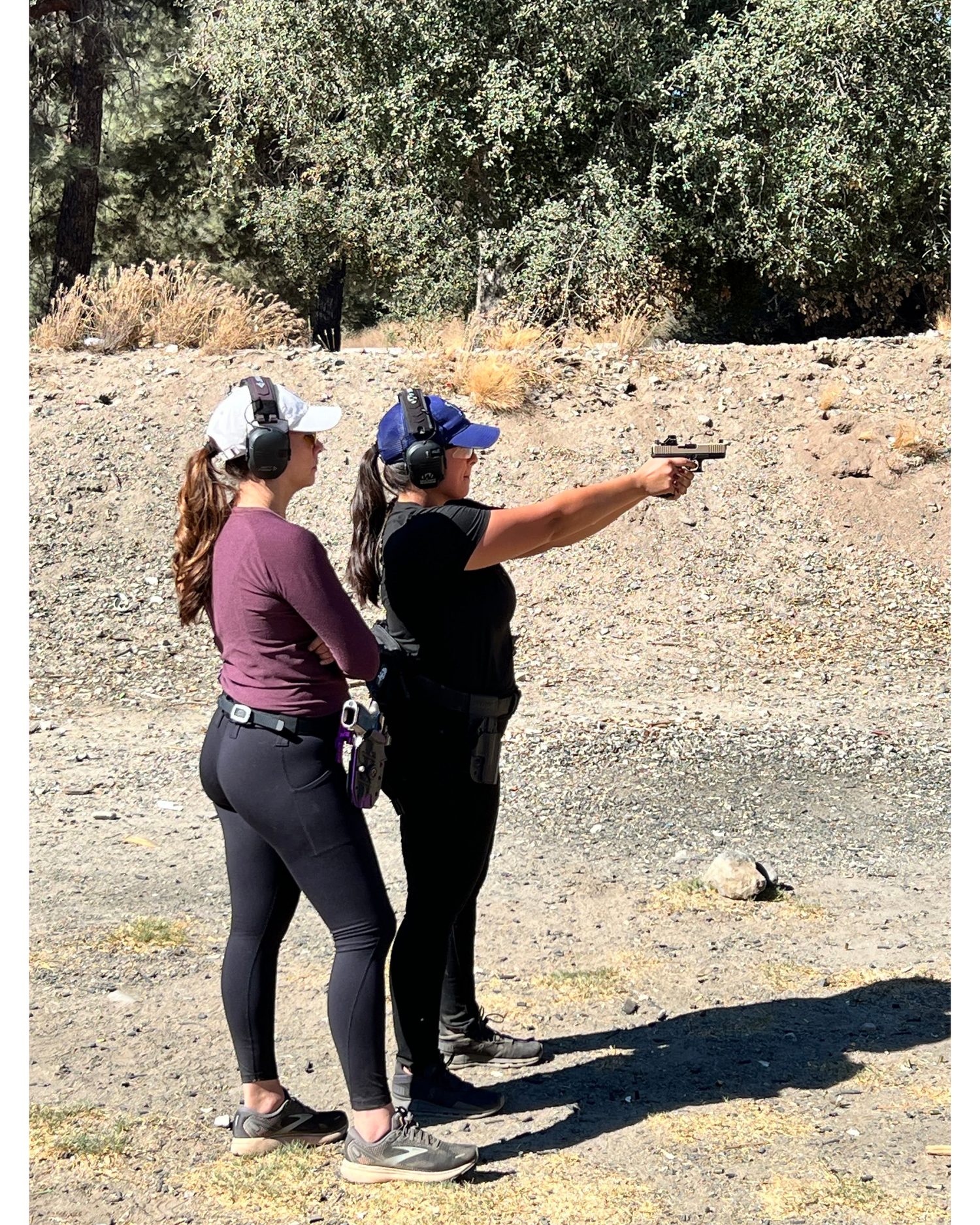 Veronica coaching a student one-on-one on handgun stance at the range